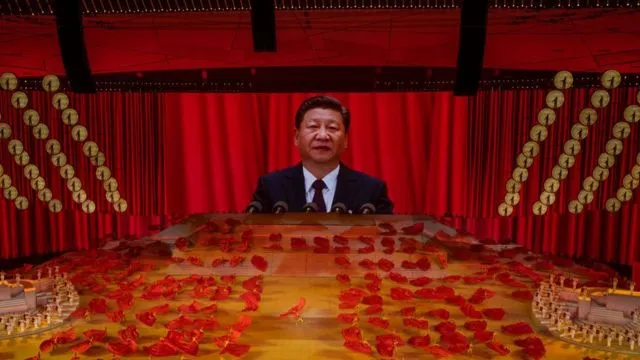 Chinese President and Chairman of the Communist Party Xi Jinping appears on a large screen as performers dance during a mass gala marking the 100th anniversary of the Communist Party on 28 June 2021.